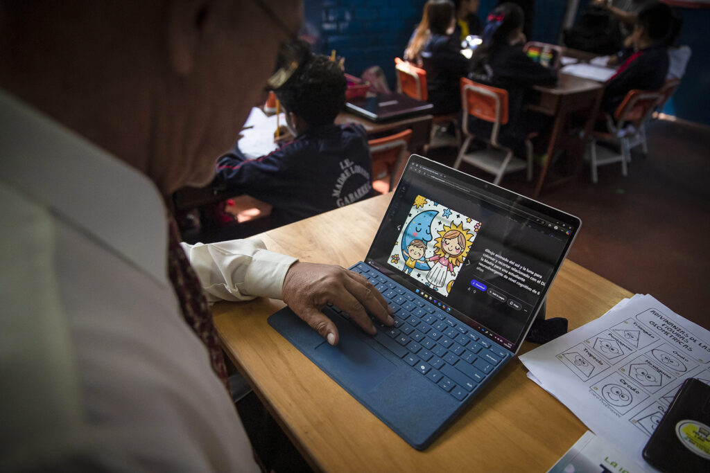 Um homem está sentado em uma mesa trabalhando em um tablet Surface com uma sessão do Copilot exibida